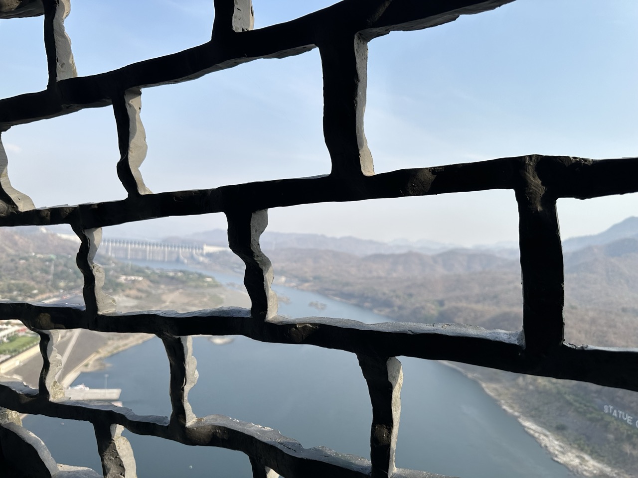 Blick durch ein Steingitter ins Tal